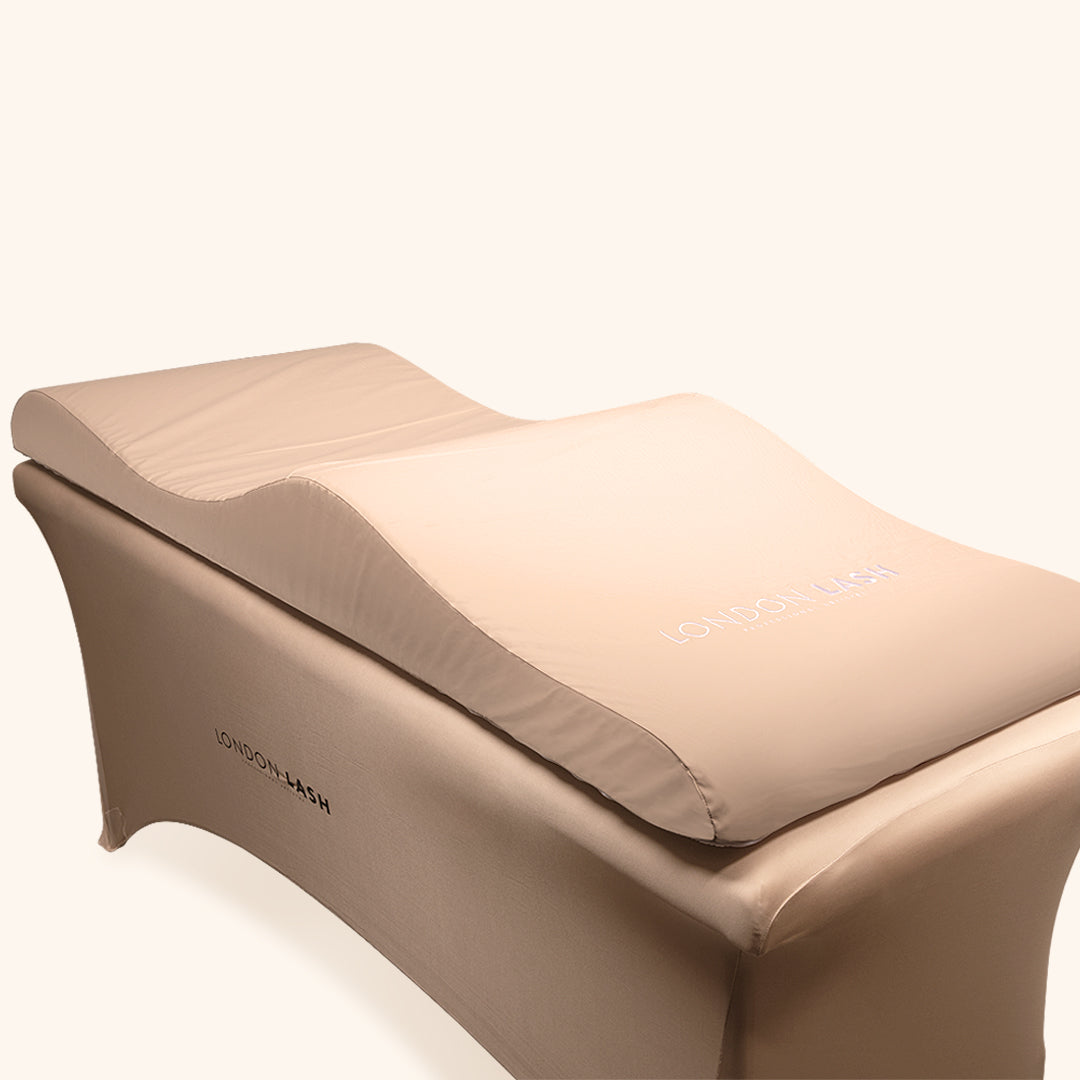 Surmatelas en mousse à mémoire pour lit de beauté ergonomique en beige, idéal pour le confort des clients dans un salon de beauté.