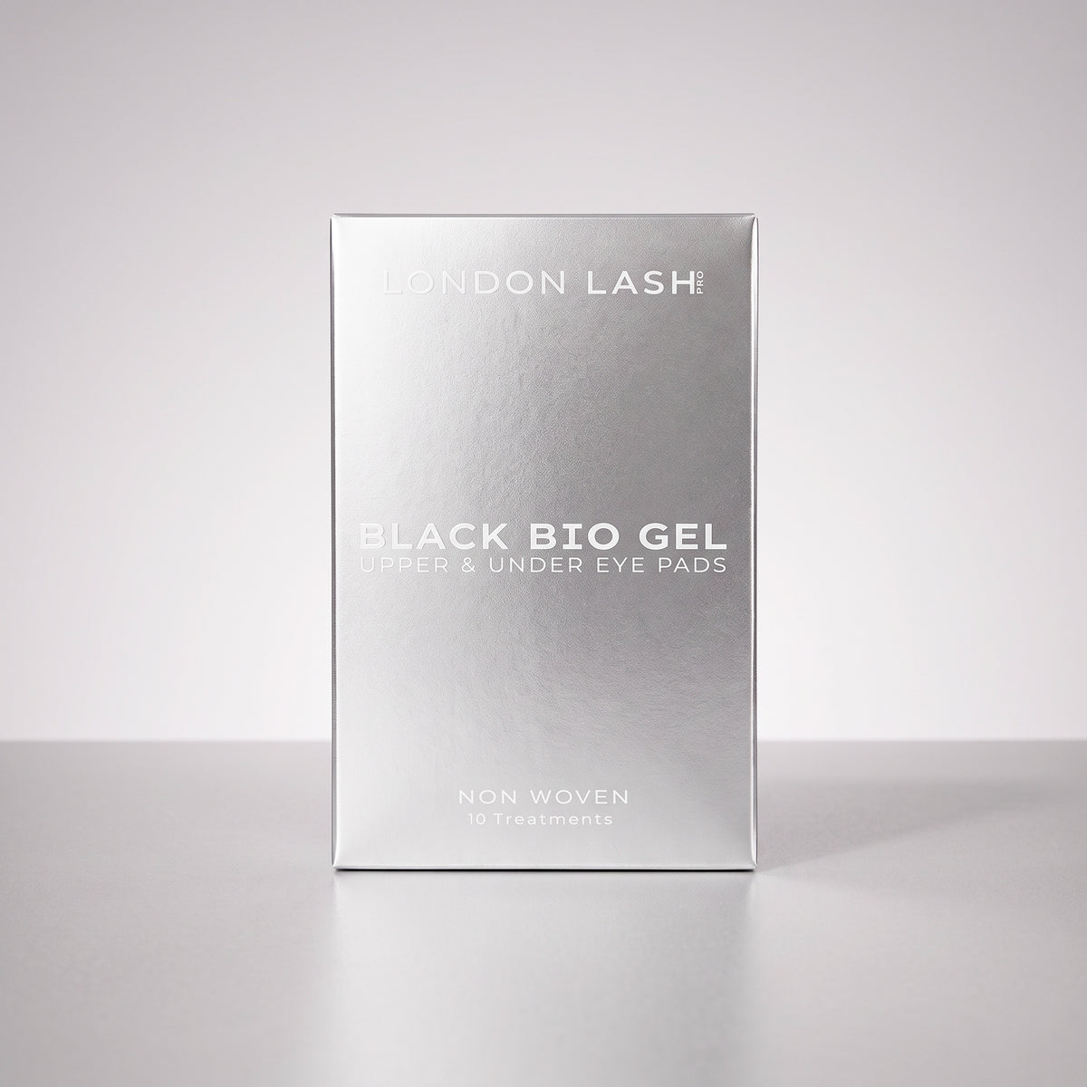 Vue de face de la boîte métallique argentée des patchs noirs bio-gel pour paupières supérieures et contour des yeux London Lash, sur un fond uni en studio.
